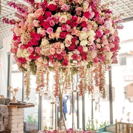 High quality ceiling floral arrangement merging geometric metalwork with faux vines, suspended artificial flower installation for wedding event decor