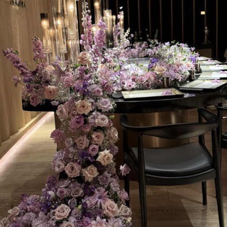 Luxury lounge interior with custom modern minimalist coffee table paired with elegant silk floral decorations for commercial hospitality design
